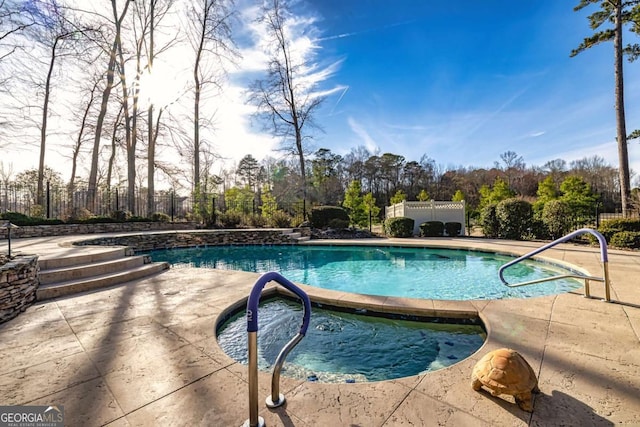 view of swimming pool featuring a fenced in pool, a patio area, fence, and an in ground hot tub