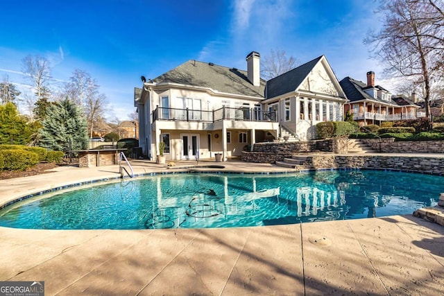 pool featuring french doors, stairway, a patio area, and a wooden deck