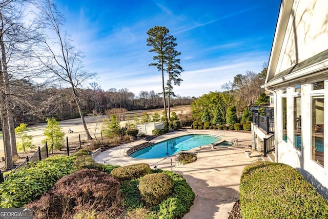 pool with a patio area and fence