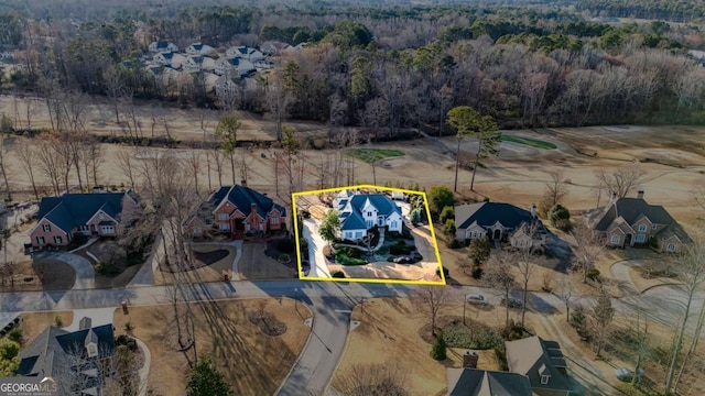 drone / aerial view featuring a wooded view and a residential view