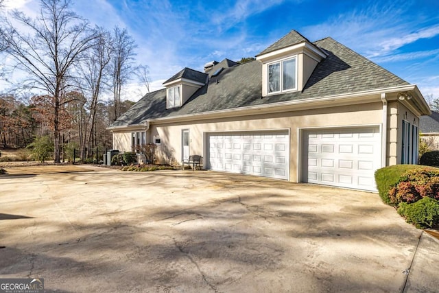 view of home's exterior featuring a shingled roof, driveway, an attached garage, and stucco siding