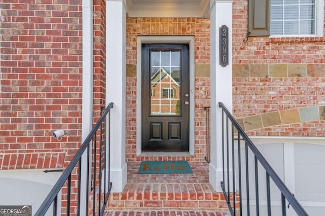 view of exterior entry with brick siding