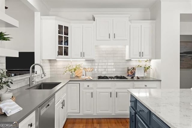 kitchen with white cabinets, glass insert cabinets, stainless steel appliances, crown molding, and a sink