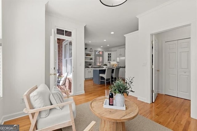 interior space featuring light wood finished floors, recessed lighting, baseboards, and ornamental molding