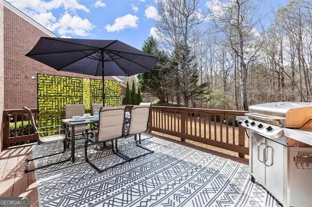 wooden deck with outdoor dining area and a grill