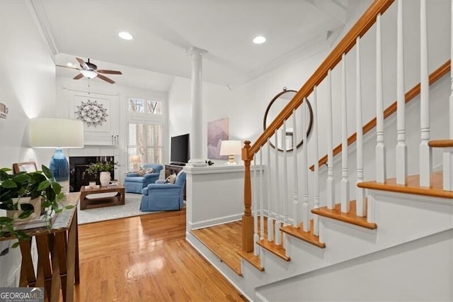 interior space with ceiling fan, recessed lighting, a fireplace, wood finished floors, and stairs