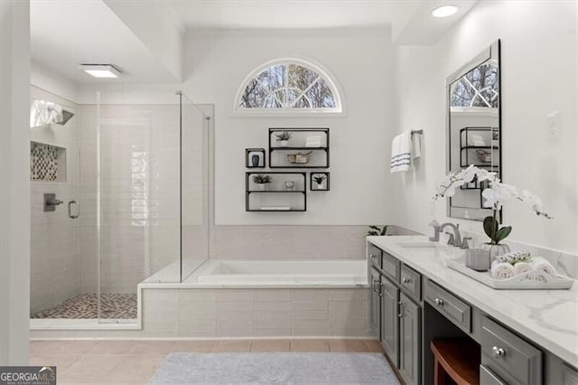 bathroom with a stall shower, tile patterned flooring, vanity, and a bath