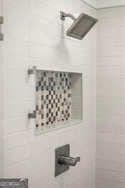 interior details featuring tiled shower