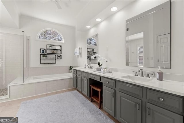 bathroom featuring double vanity, a sink, a bath, and tile patterned floors