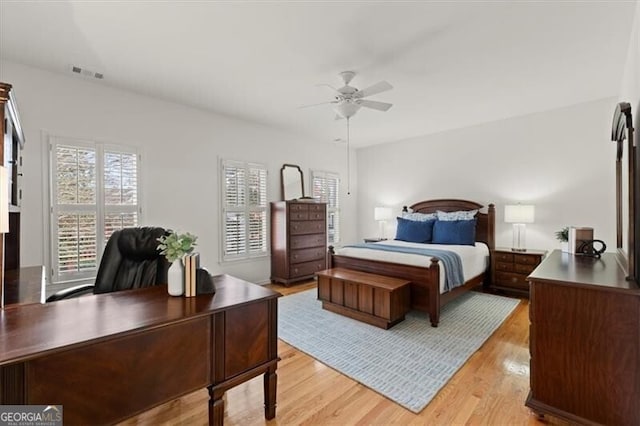 bedroom with light wood-style floors, ceiling fan, multiple windows, and visible vents