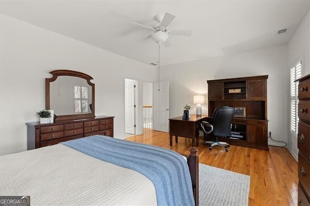 bedroom with ceiling fan, wood finished floors, and visible vents