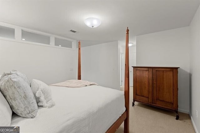 bedroom with baseboards and light colored carpet