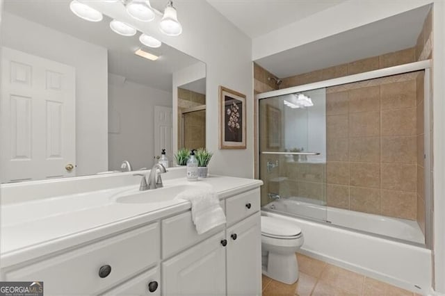 full bathroom with toilet, vanity, bath / shower combo with glass door, and tile patterned floors