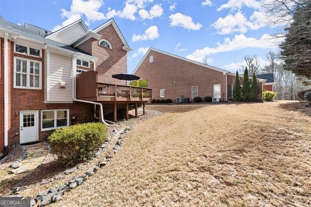 rear view of property with brick siding and a wooden deck