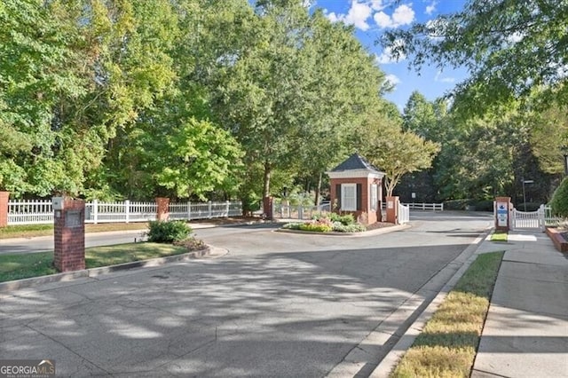 view of road with a gate, curbs, and a gated entry