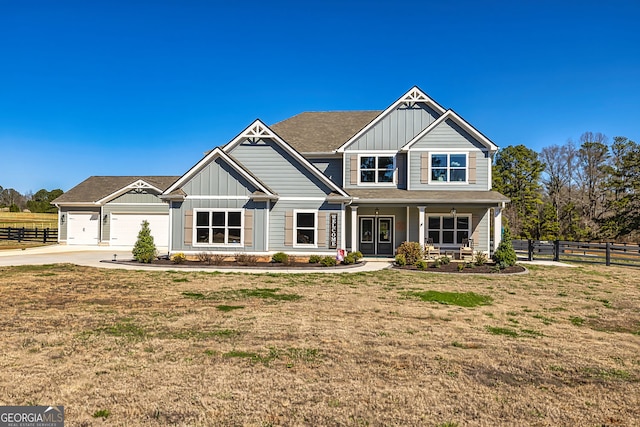 craftsman-style house with board and batten siding, a front lawn, and fence