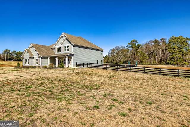 view of side of home with a lawn and fence