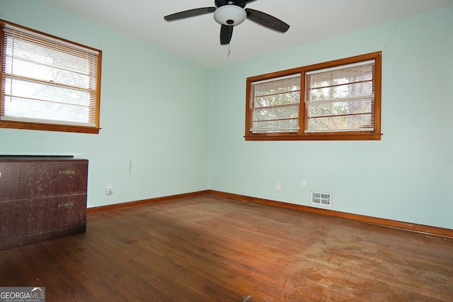 spare room with visible vents, dark wood finished floors, baseboards, and ceiling fan