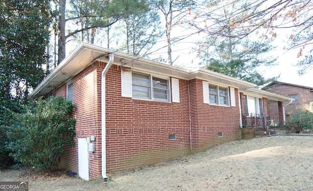 view of property exterior featuring brick siding and crawl space