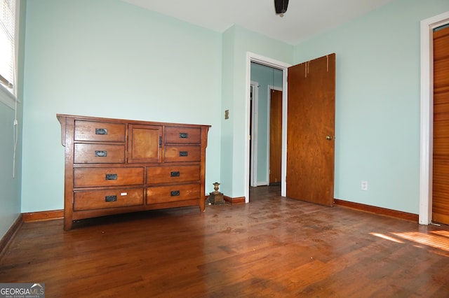 unfurnished bedroom with dark wood-style floors and baseboards