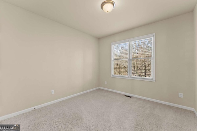 spare room featuring light carpet, baseboards, and visible vents