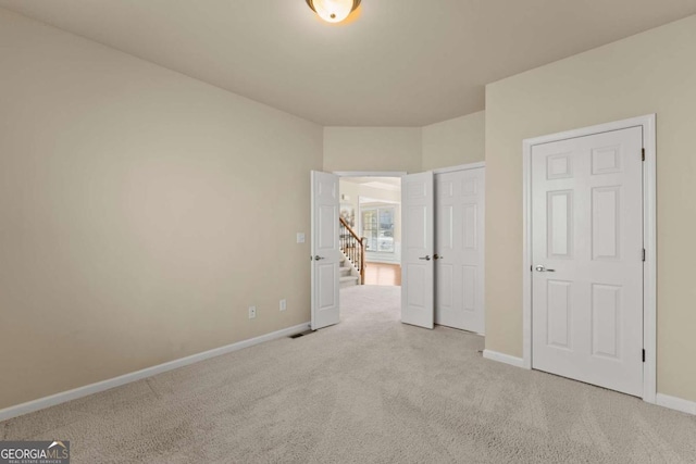 unfurnished bedroom with light carpet, visible vents, and baseboards