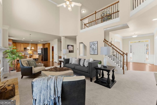 living room with crown molding, recessed lighting, stairway, ceiling fan, and ornate columns