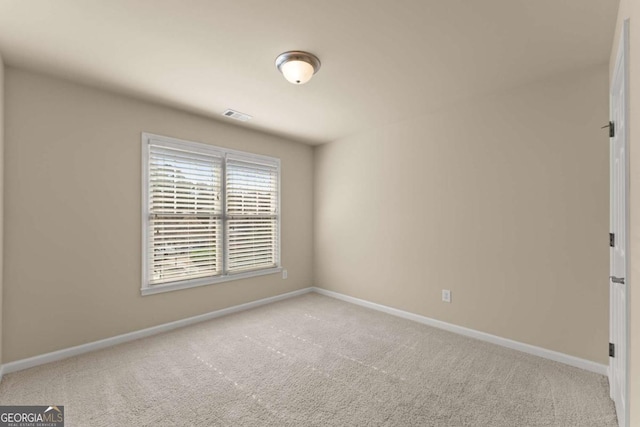 unfurnished room featuring visible vents, baseboards, and light colored carpet