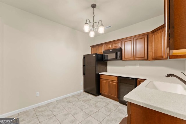 kitchen featuring a sink, light countertops, black appliances, brown cabinetry, and decorative light fixtures