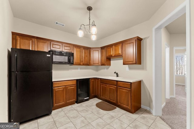 kitchen with wine cooler, light countertops, visible vents, brown cabinetry, and black appliances