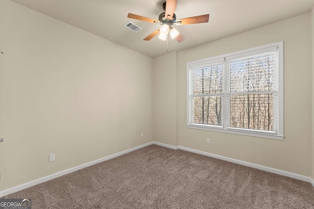 carpeted empty room with visible vents, ceiling fan, and baseboards