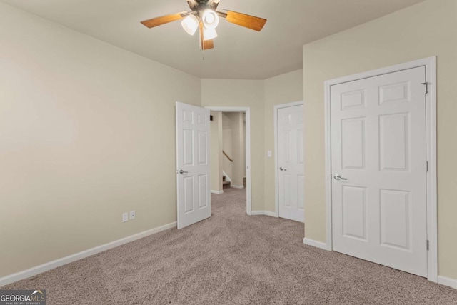 unfurnished bedroom featuring light carpet, a ceiling fan, and baseboards