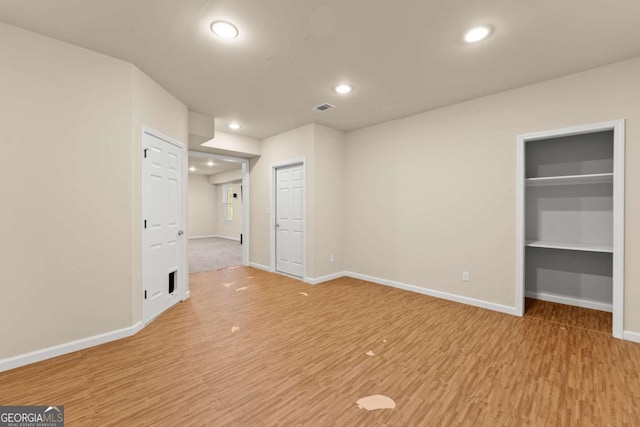 spare room with recessed lighting, visible vents, baseboards, and wood finished floors