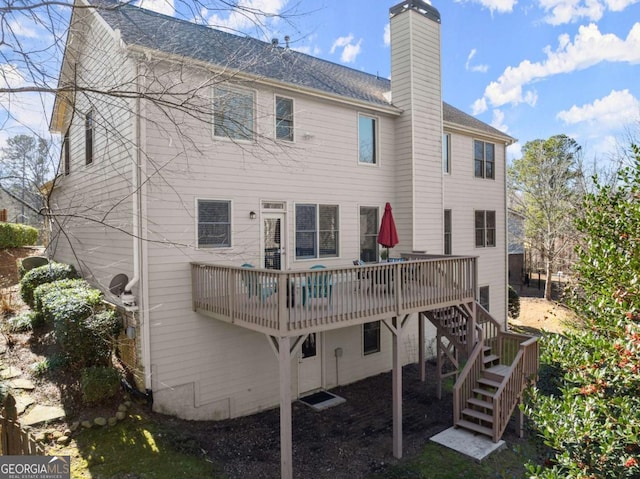 back of property with a shingled roof, stairs, a chimney, and a deck