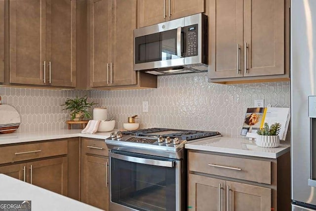 kitchen with light countertops, appliances with stainless steel finishes, and decorative backsplash