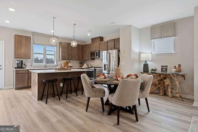 dining space with light wood-style flooring, baseboards, and recessed lighting