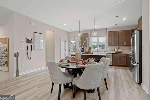 dining area with light wood-style flooring, baseboards, and recessed lighting