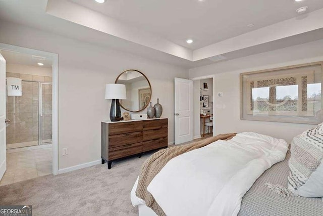 bedroom with recessed lighting, a raised ceiling, light colored carpet, connected bathroom, and baseboards