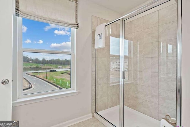 full bathroom with a stall shower and baseboards