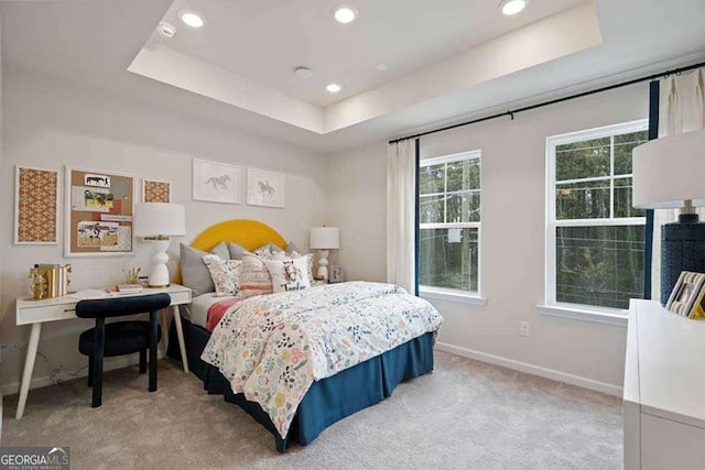 bedroom with a tray ceiling, baseboards, carpet, and recessed lighting