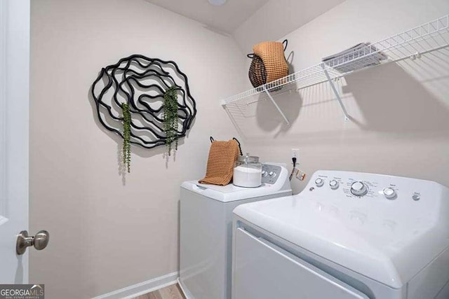 washroom featuring laundry area, washing machine and clothes dryer, and baseboards