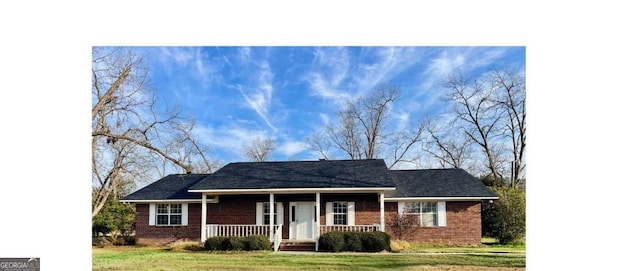 ranch-style house with a front yard, a porch, and brick siding