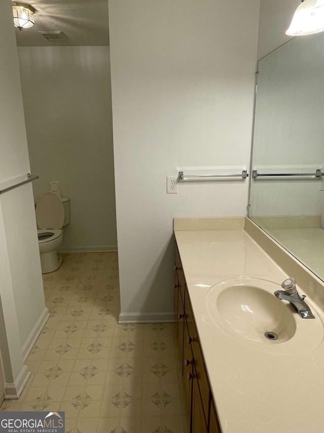 714 E Simon St, Glennville, GA 30427 - bathroom with tile patterned floors, baseboards, toilet, and vanity