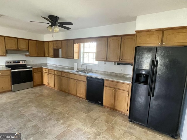 kitchen with light countertops, brown cabinetry, a sink, under cabinet range hood, and black appliances