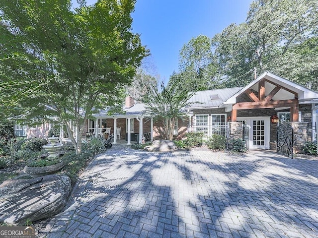 view of front of house with stone siding and french doors