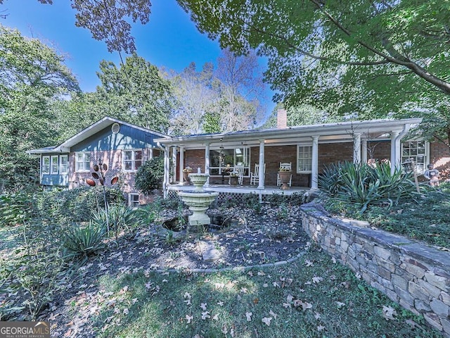 ranch-style home with a chimney and brick siding