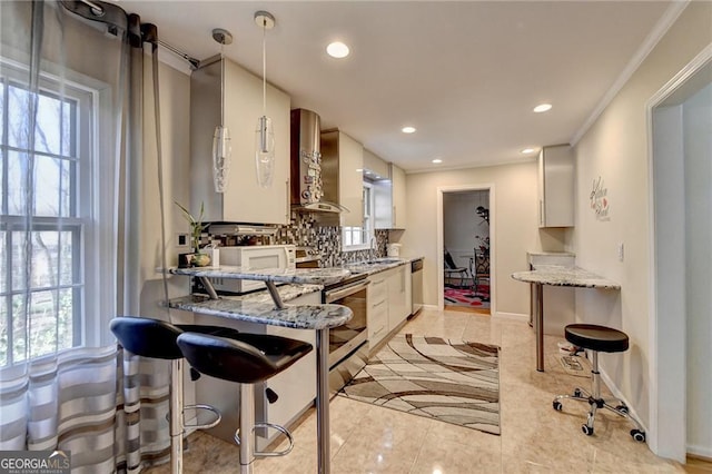 kitchen featuring plenty of natural light, wall chimney exhaust hood, hanging light fixtures, stainless steel appliances, and backsplash