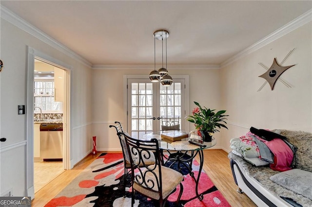 dining area featuring light wood-style flooring and crown molding