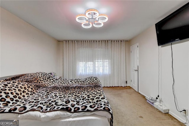 bedroom with a notable chandelier and light colored carpet