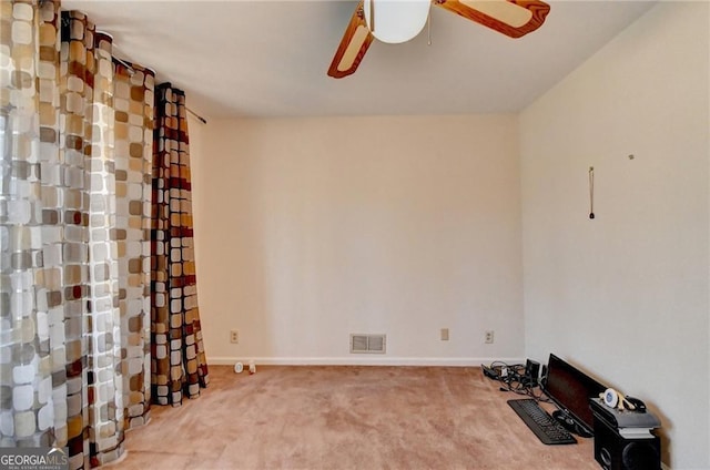 unfurnished room with carpet floors, visible vents, baseboards, and a ceiling fan